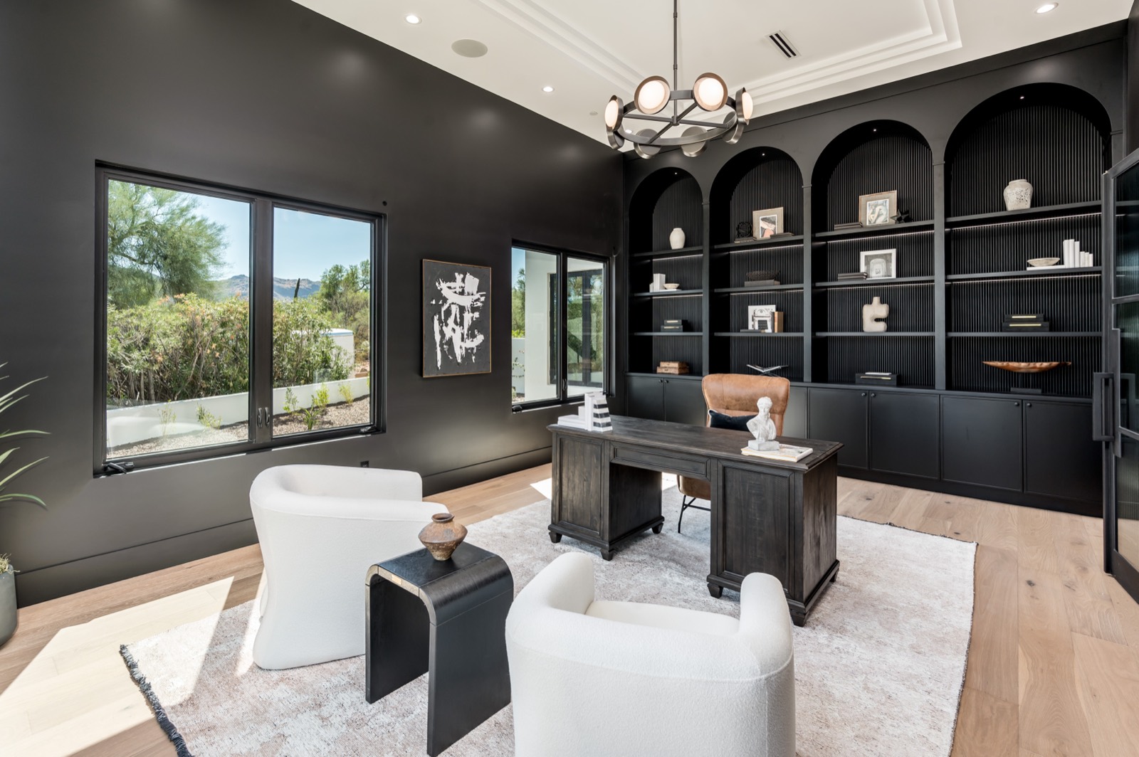 Study lined with arched black built-in shelving