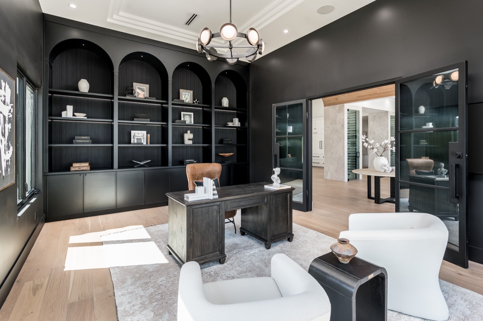 Study with black arched bookcases and a desk