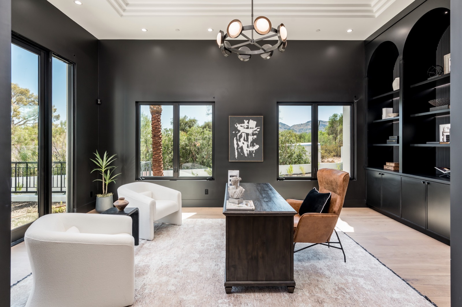 Black built-ins and a chandelier in the study