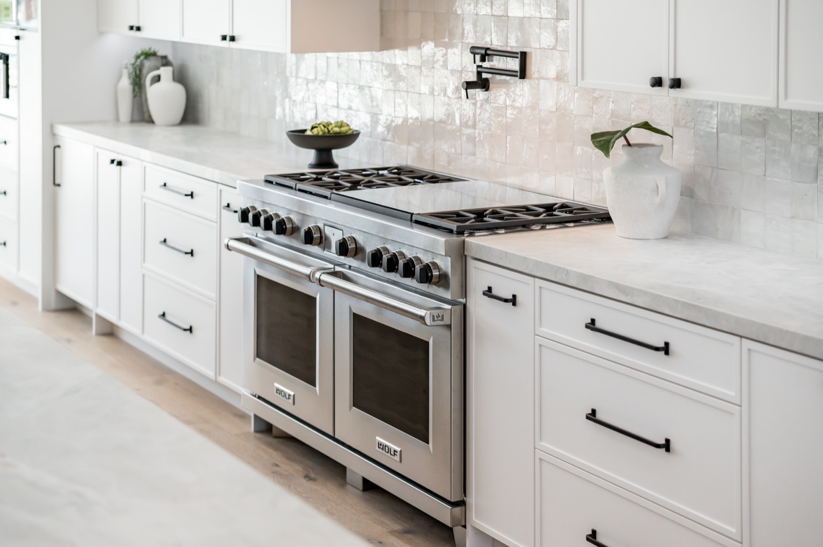 Range wall with white cabinetry and a professional range
