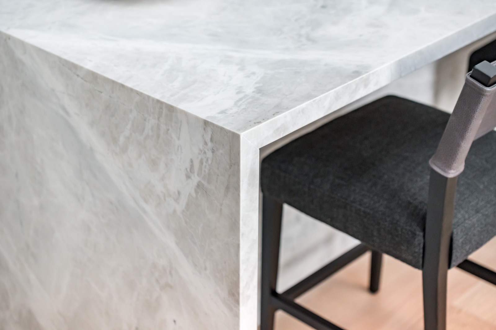 Detail of a waterfall stone edge beside a bar stool