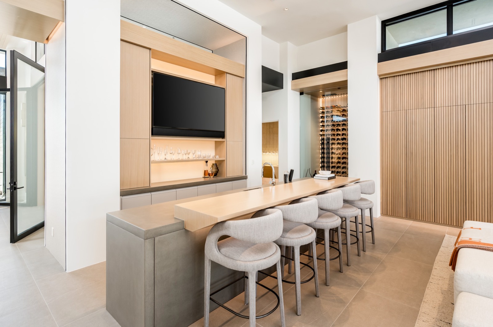 Bar with oak cabinetry, a stone counter and bar stools