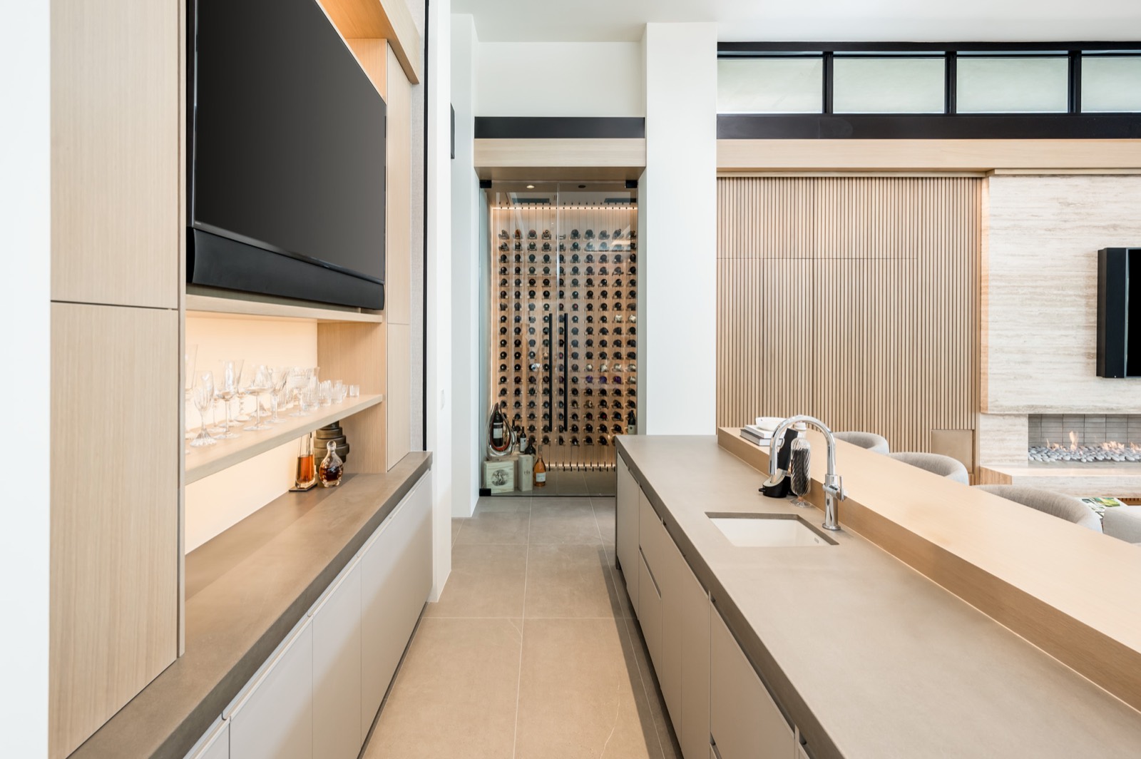 Bar and wine display with oak cabinetry and back-lit shelving