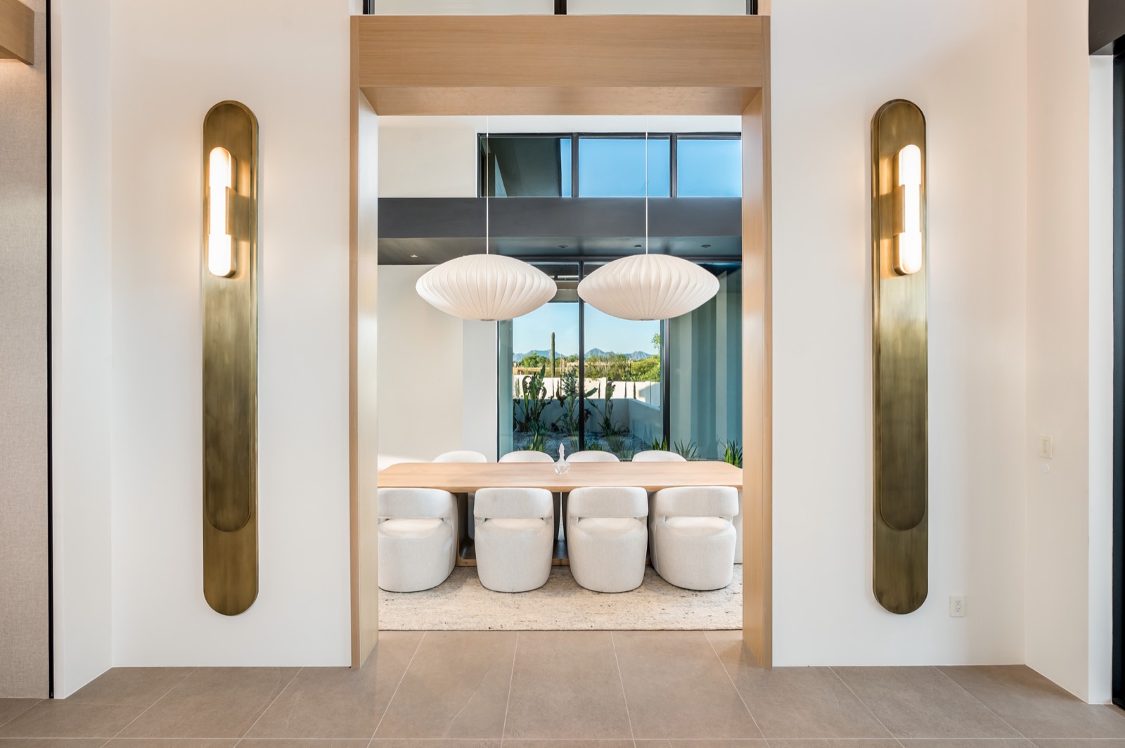 Dining room framed by plaster walls with brass inlays and built-in oak display