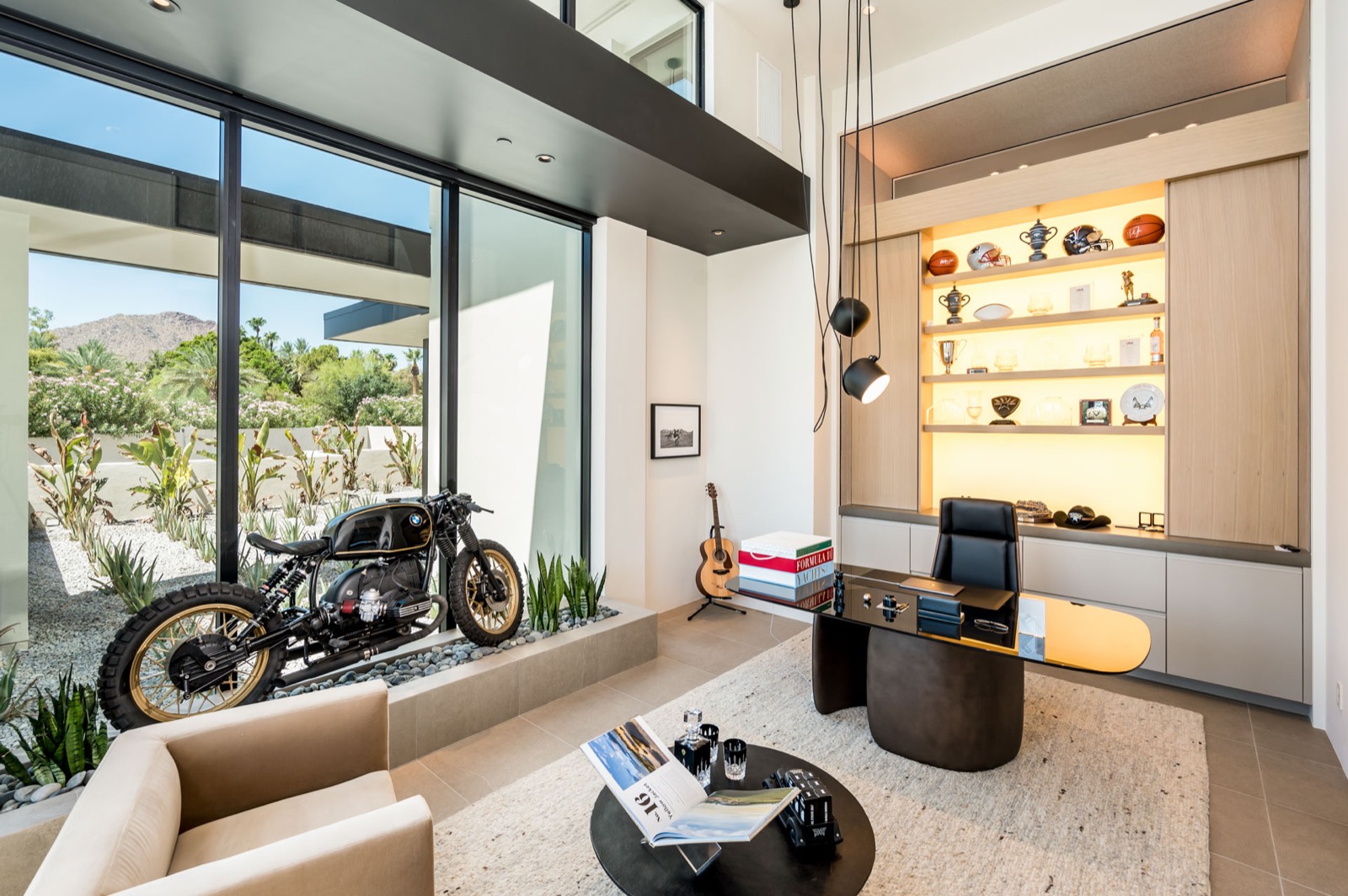 Study with oak display shelving, a desk and a motorcycle on display