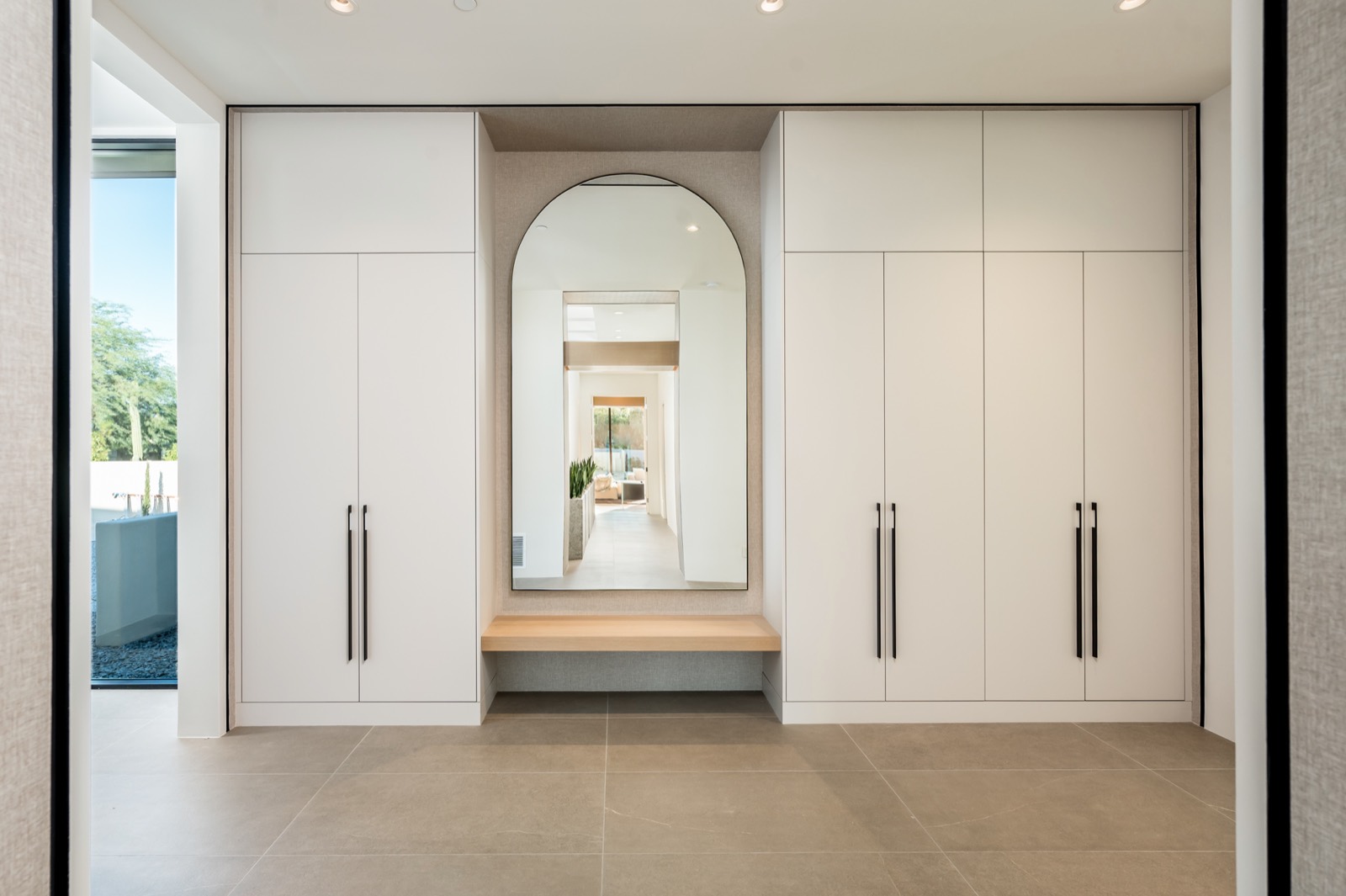 White cabinetry wall with an arched niche