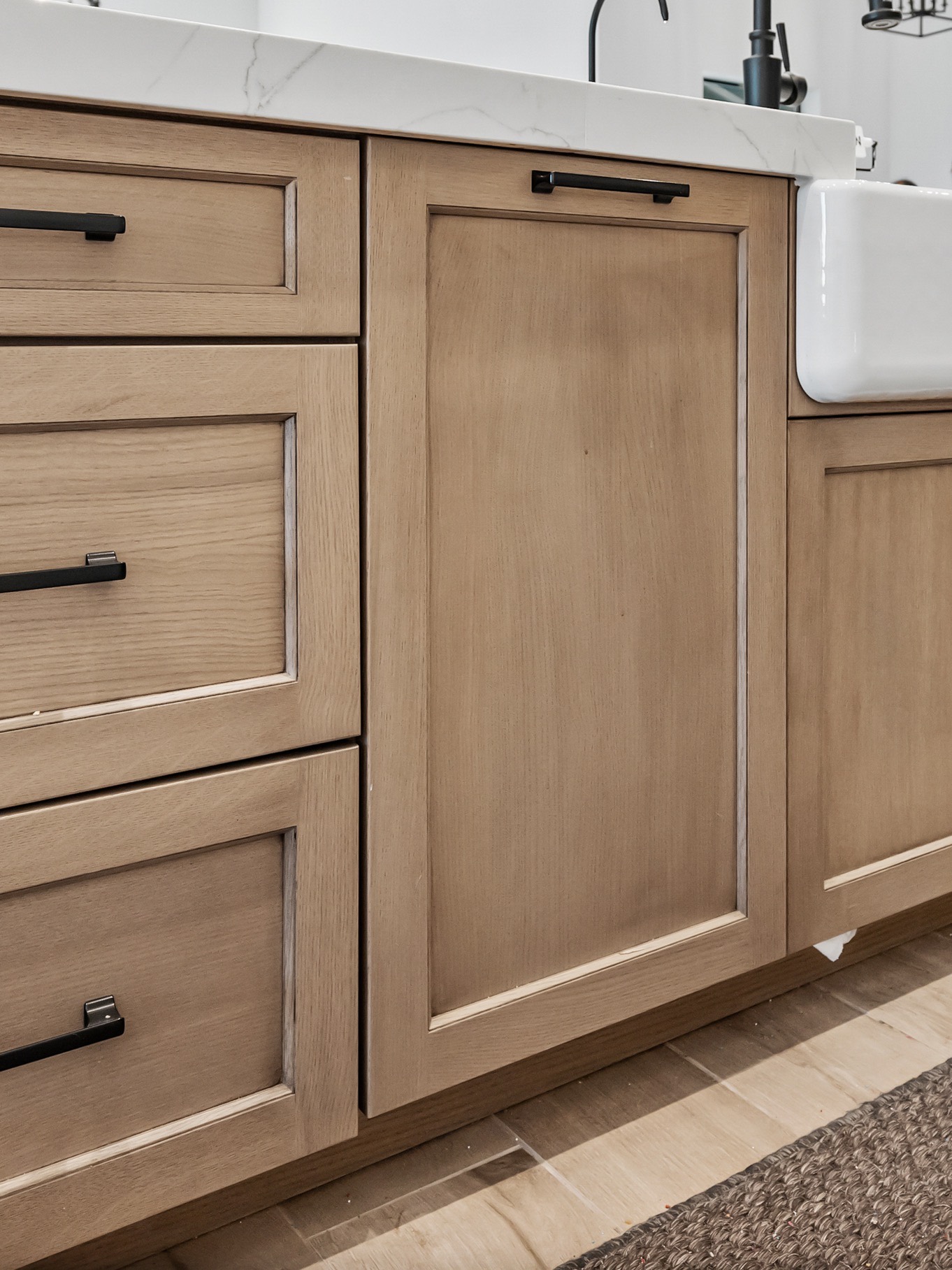 Recessed-panel oak drawer fronts and door with matte black pulls