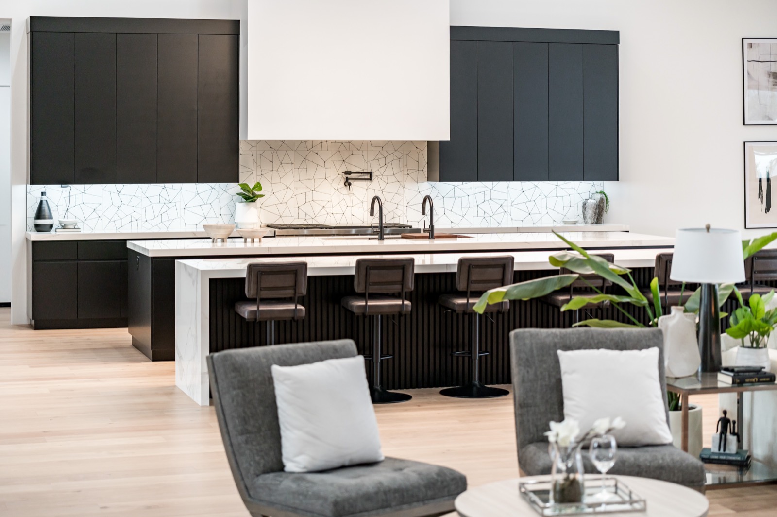 Black kitchen and island seen across the living room