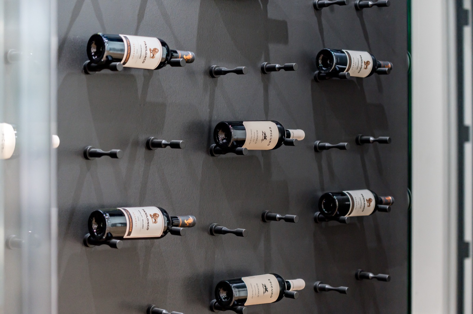 Wine bottles mounted on a black peg wall