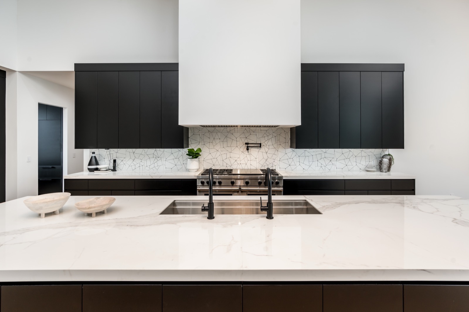 Plaster hood between tall black cabinetry