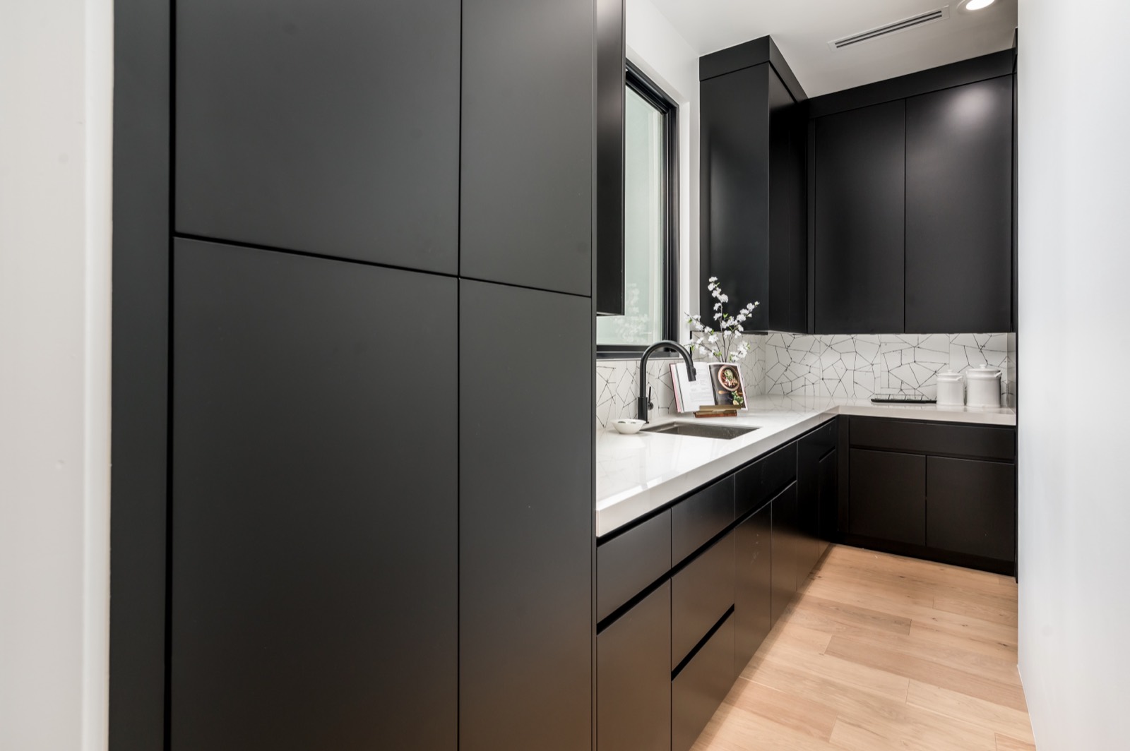 Tall black cabinetry with integrated ovens