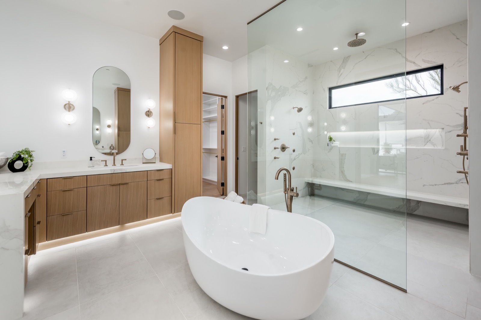 Primary bath with white oak vanity and freestanding tub