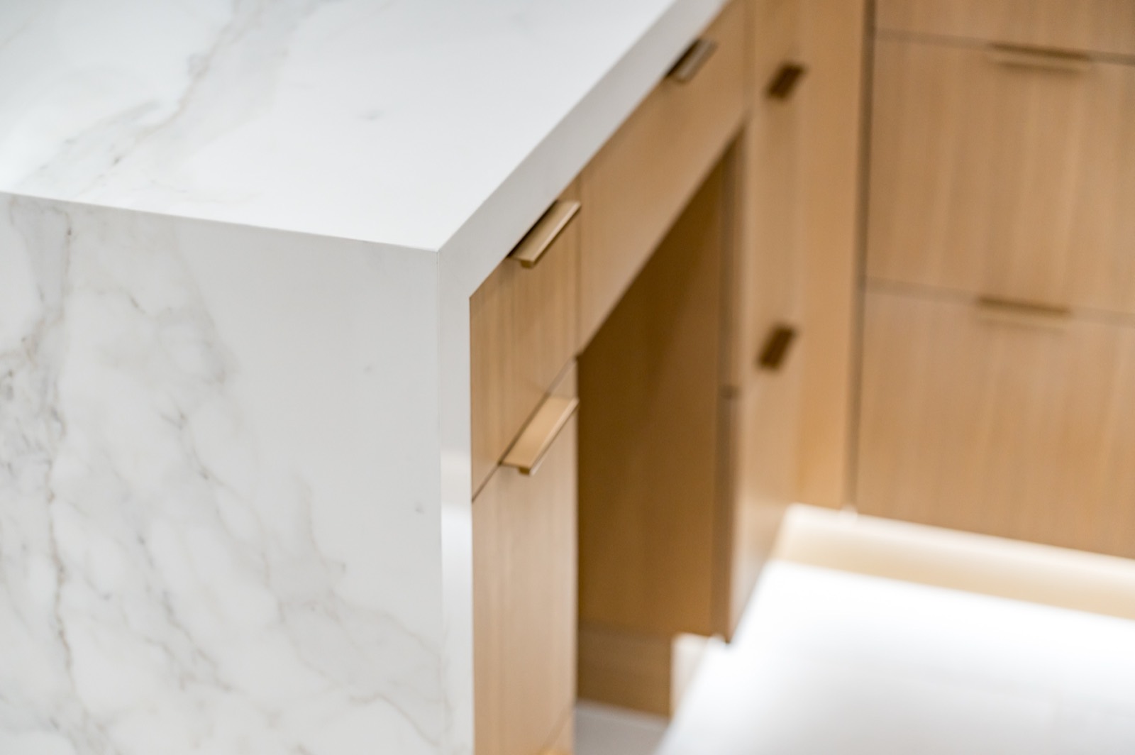 Detail of an under-lit oak vanity and marble top