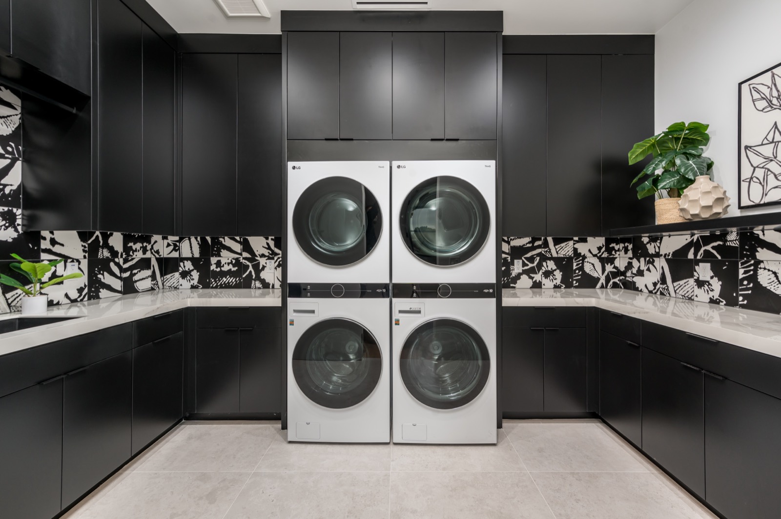 Black laundry with stacked machines and patterned tile