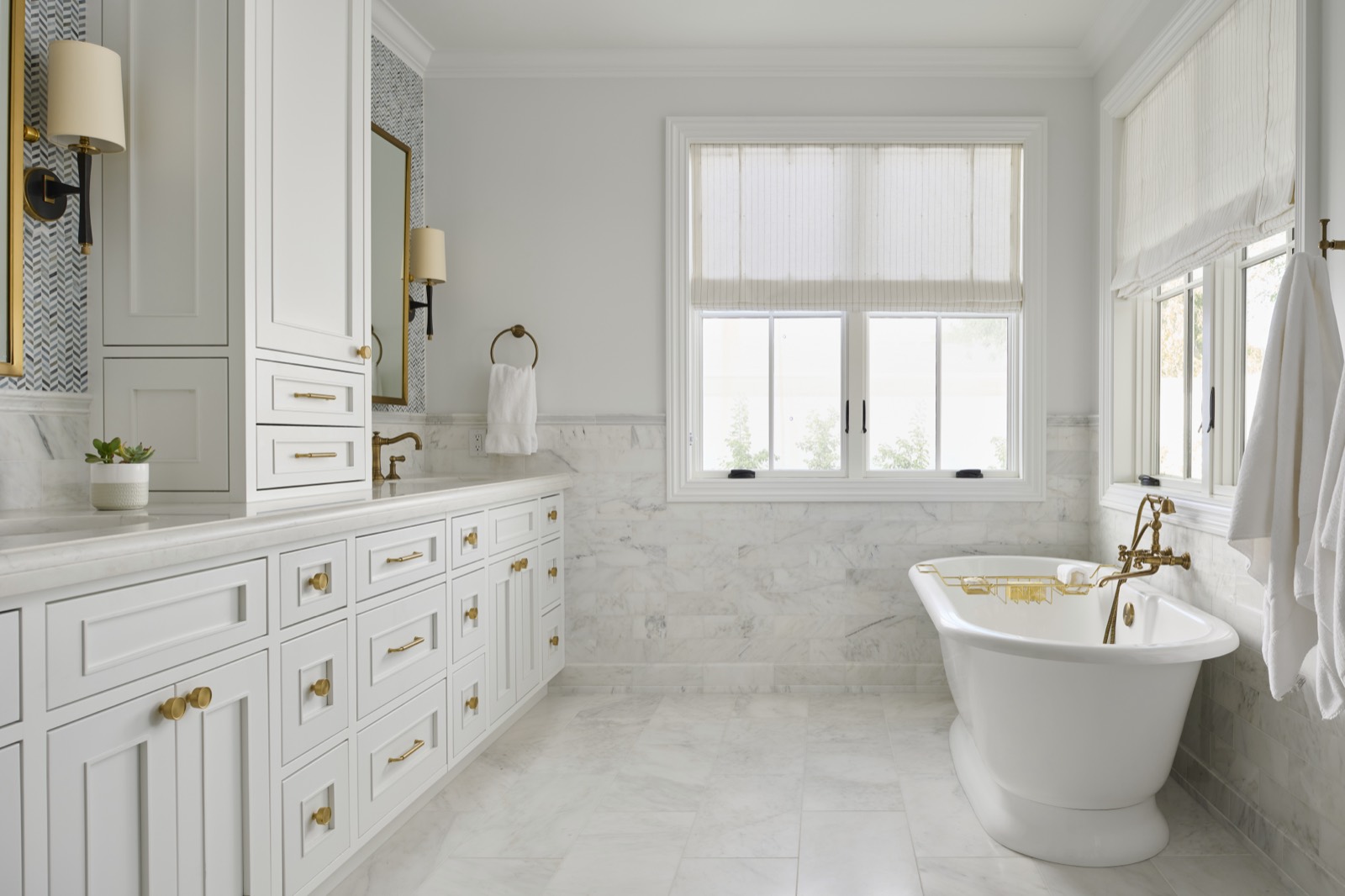 Primary bath with white cabinetry and a freestanding tub