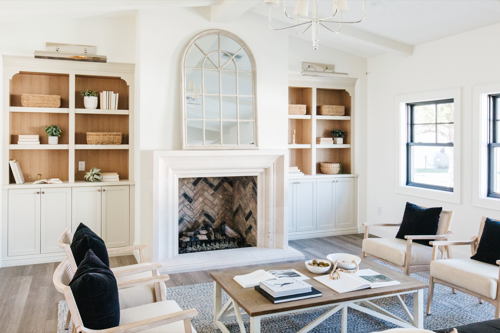 Living room with arched built-in bookcases flanking a fireplace