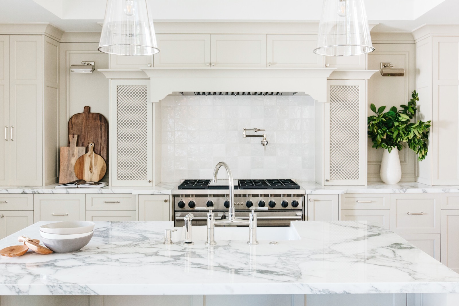 Range wall with a plaster hood and a marble-topped island