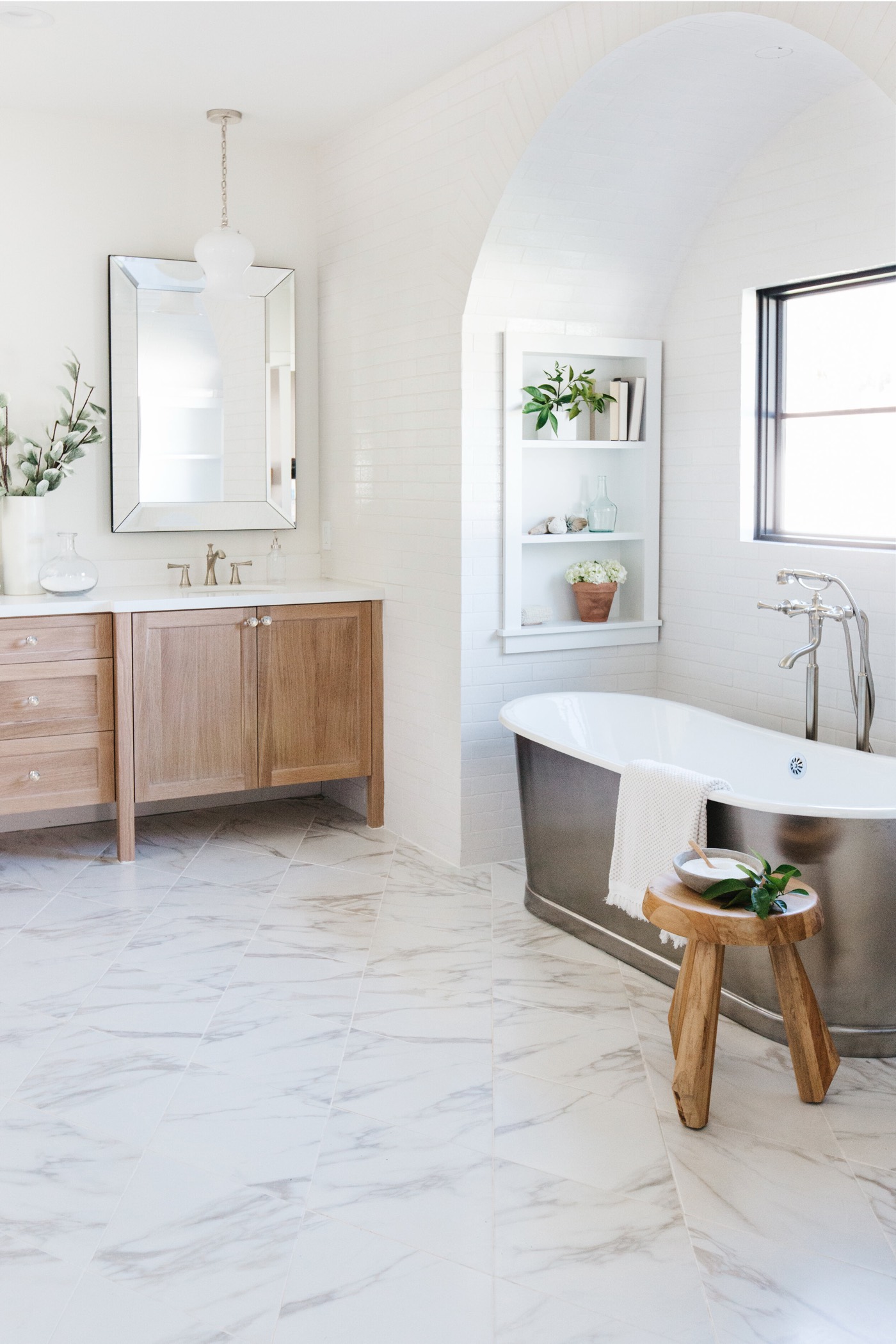 White oak vanity and freestanding tub in a primary bath