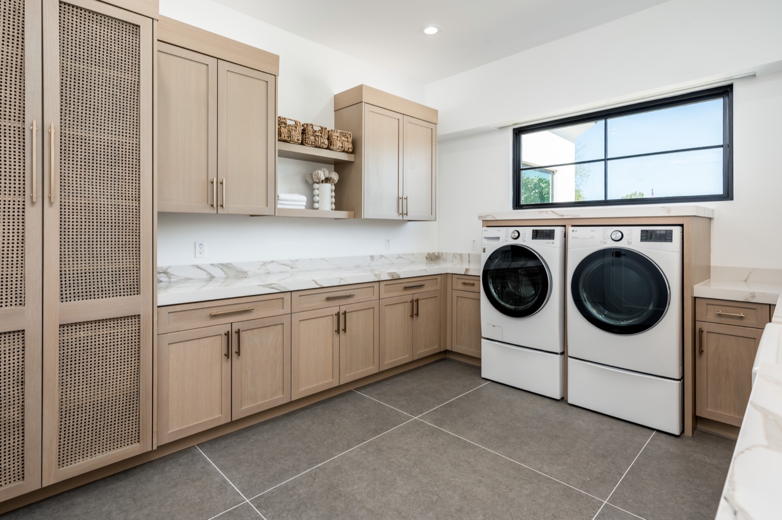 Laundry with oak cabinetry and cane-fronted doors