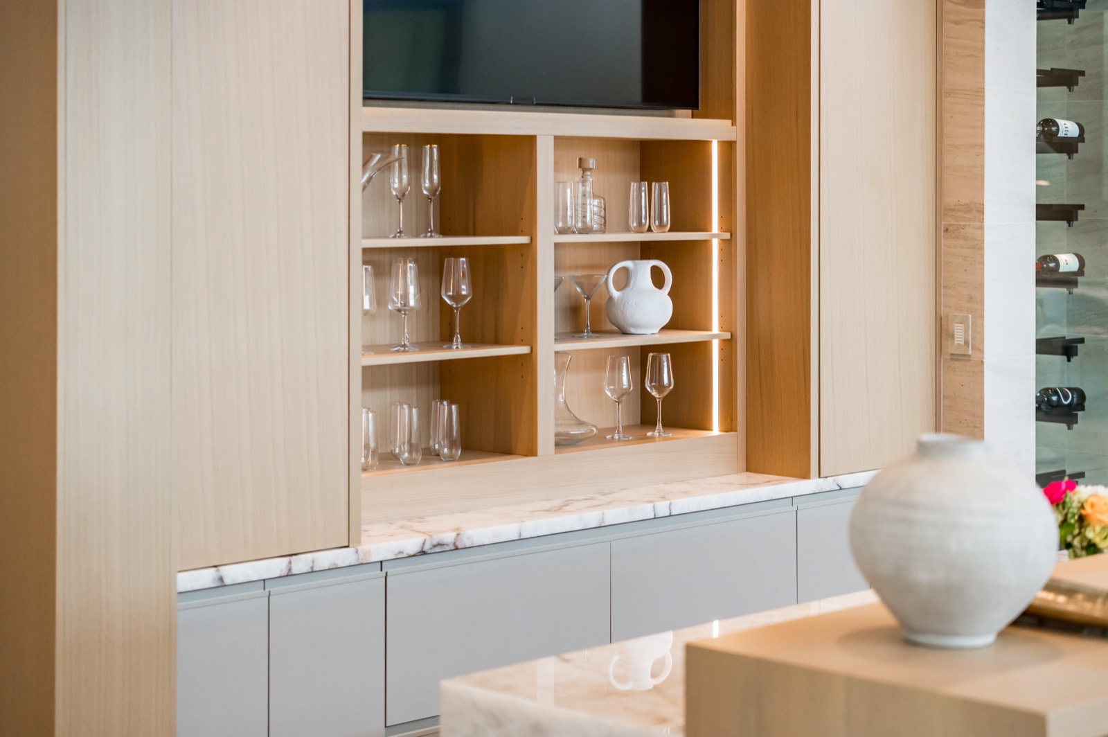 Oak shelving and bar cabinetry with ceramic display pieces