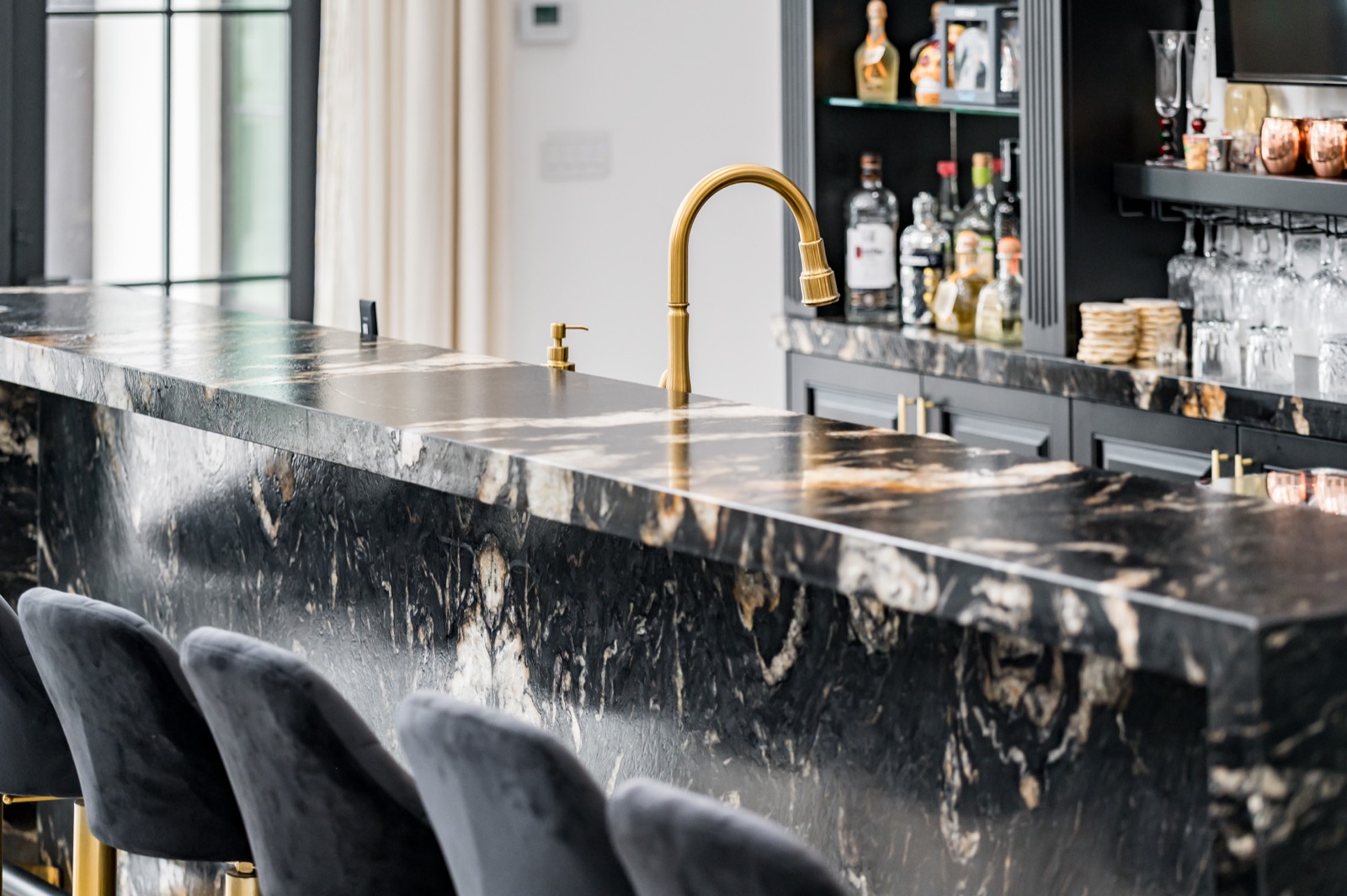 Black stone bar counter with brass fixtures