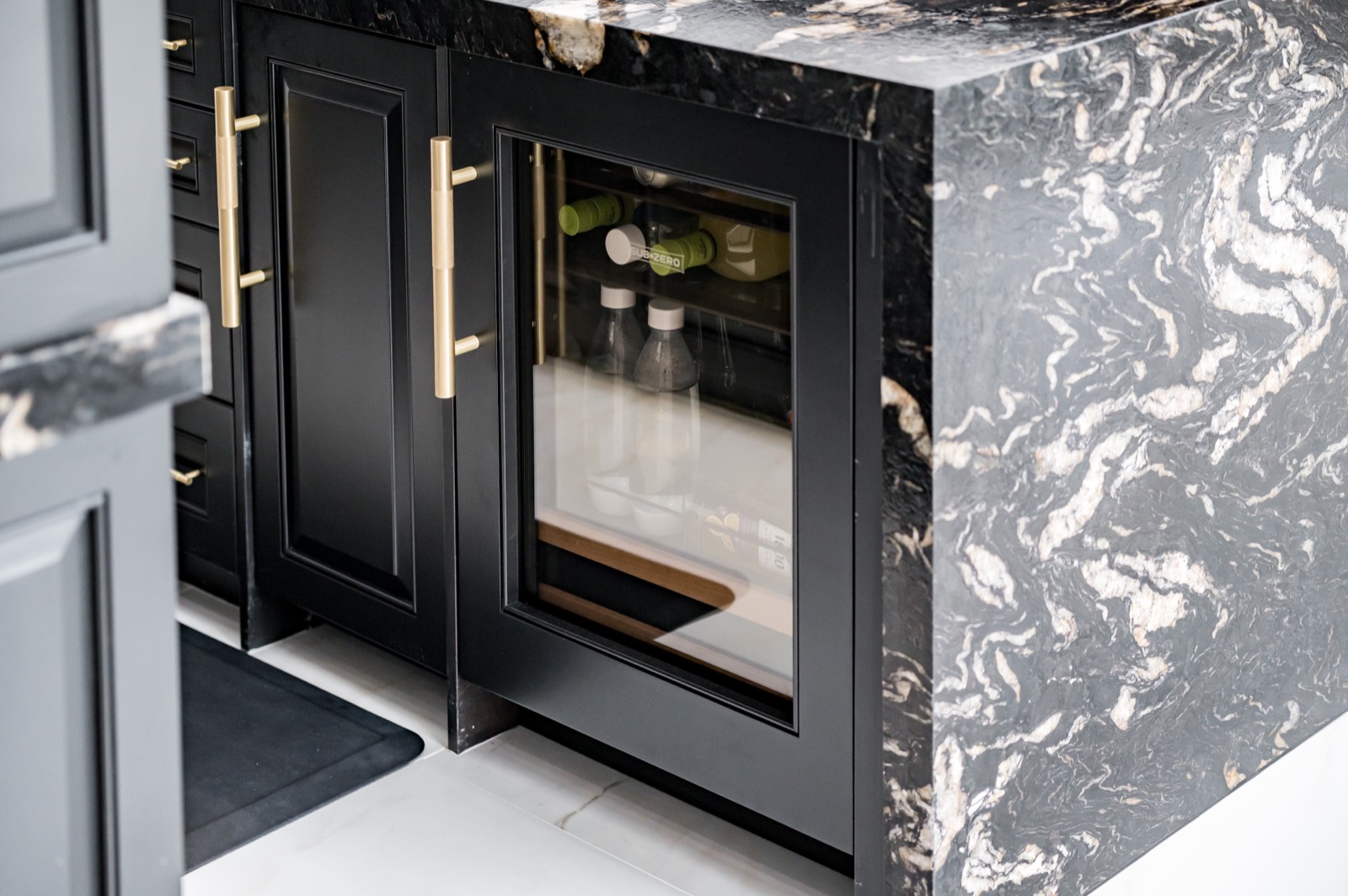 Wine refrigerator set into black cabinetry