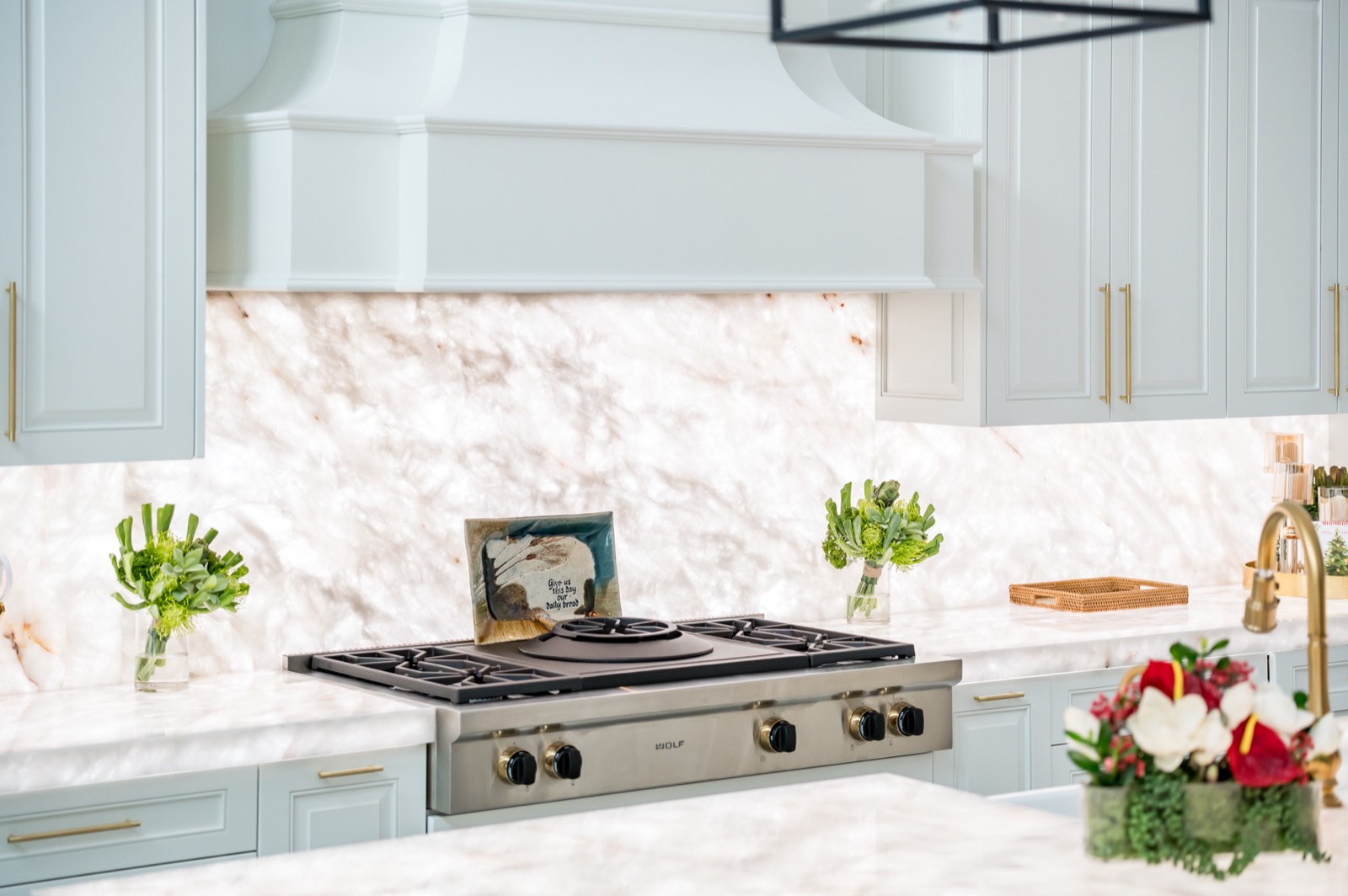 Range wall with white cabinetry and a marble backsplash