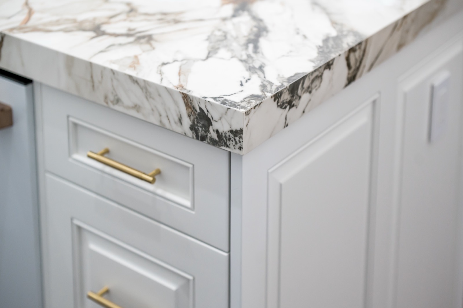 Detail of a thick marble edge on painted cabinetry