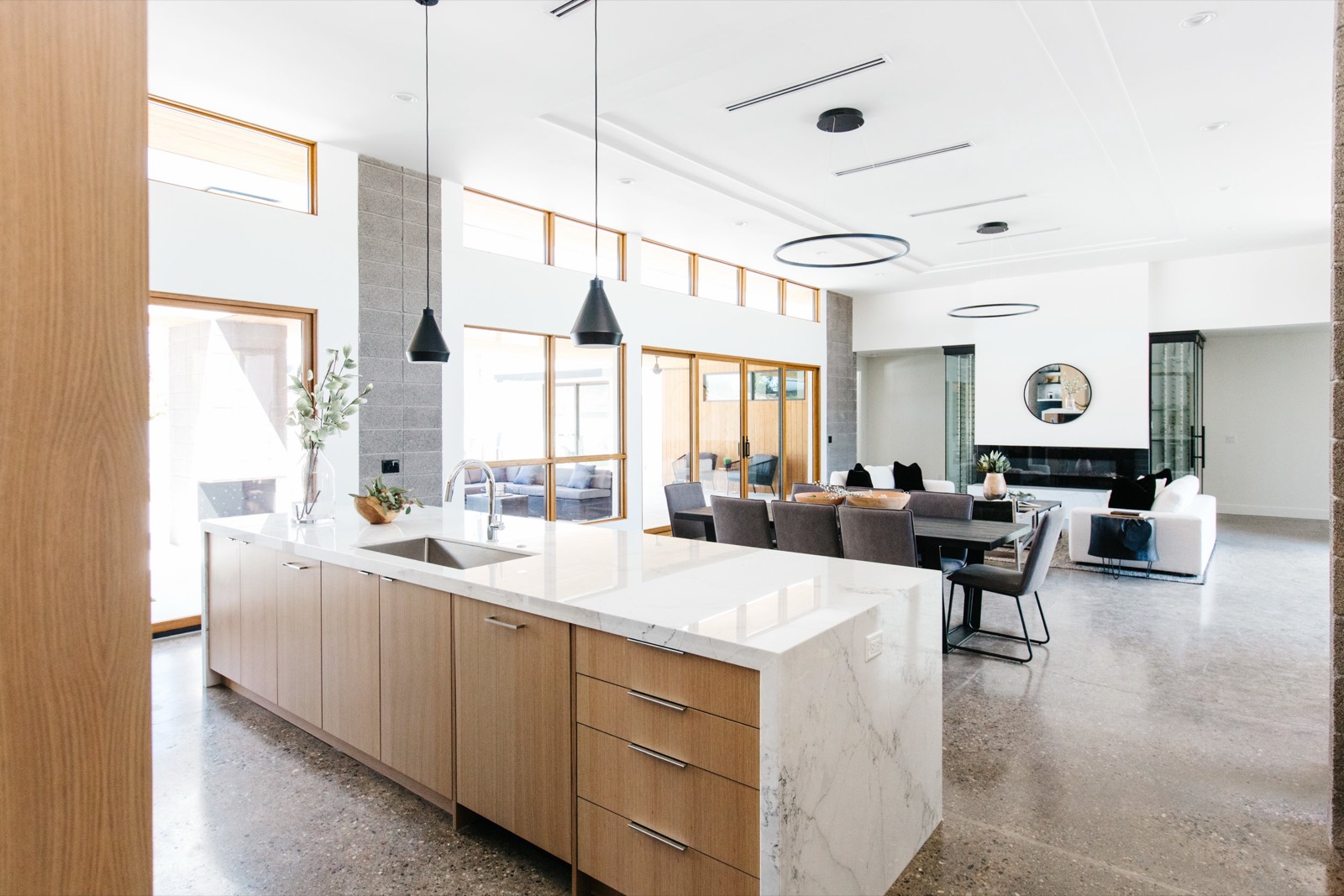 Oak island with a stone top in a bright open kitchen