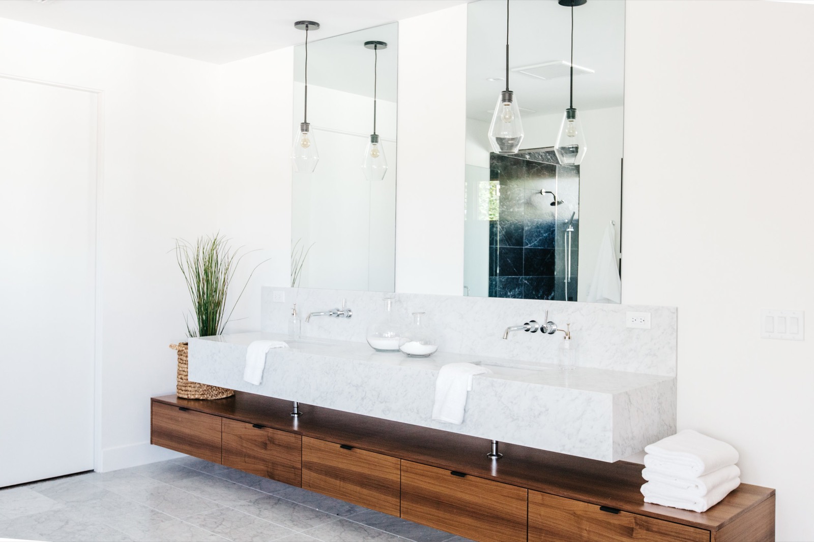 Floating walnut vanity with two vessel sinks
