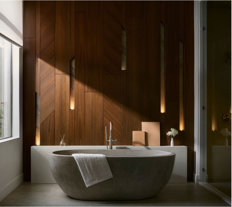 Primary bath lined in walnut paneling with a stone tub