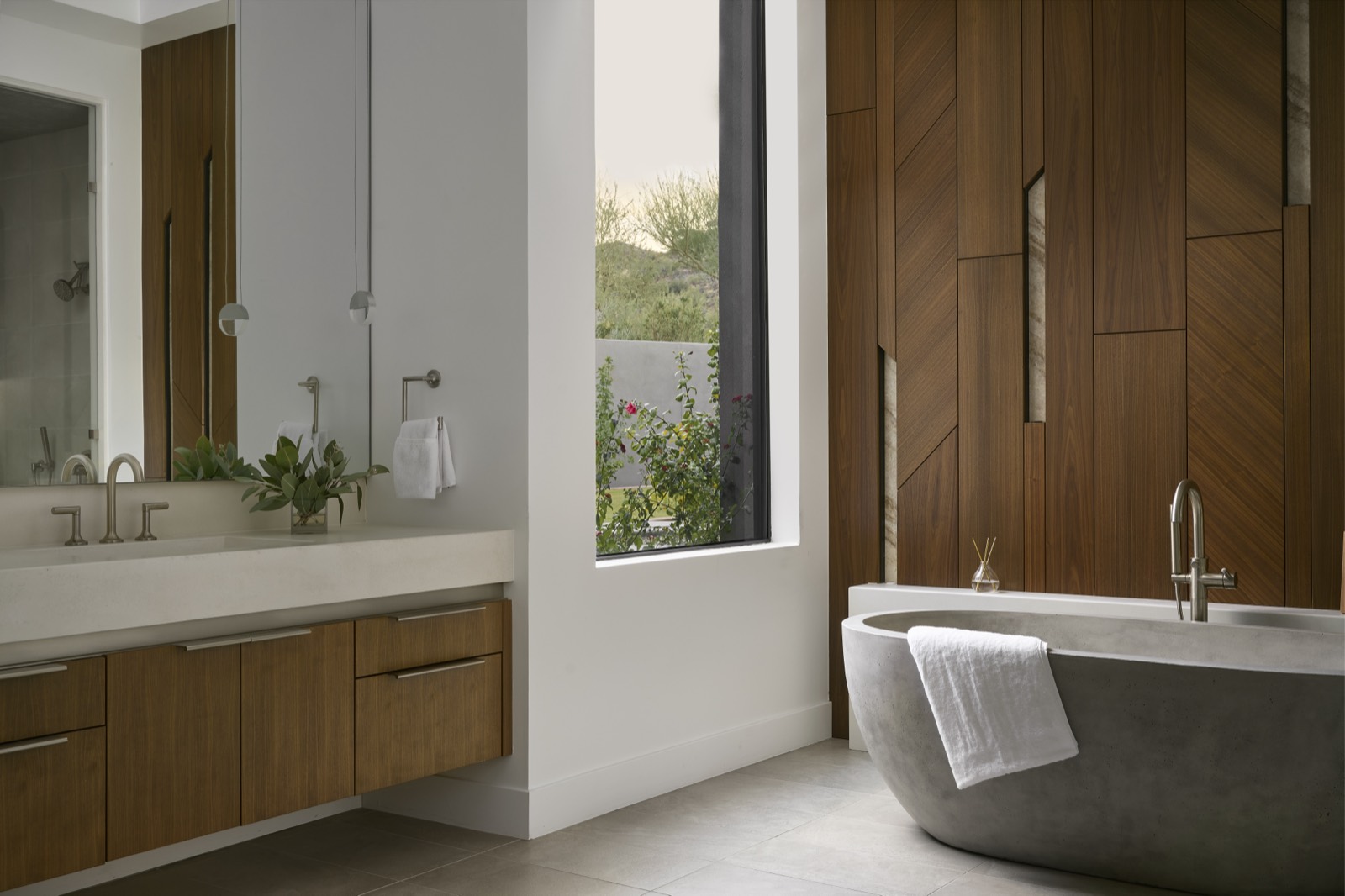 Floating walnut vanity beside a window